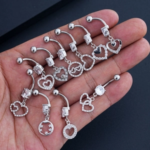 Macro detail of stainless steel belly rings set with heart-shaped zircon stones