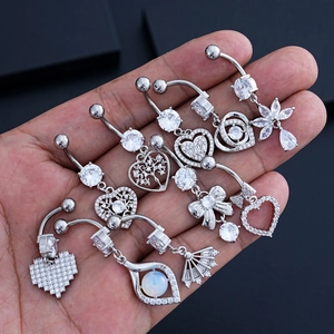 Detalle de 9 piercings de ombligo en acero inoxidable con circonitas y diseños de corazones