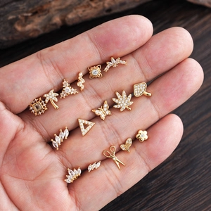 Set de 14 elegantes pendientes de acero inoxidable dorados con circonitas y formas creativas