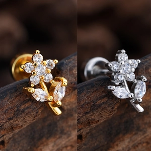 Macro shot of gold and silver flower stud earrings with sparkling cubic zirconia stones