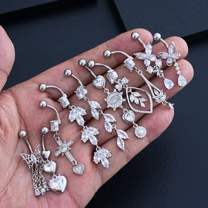 Dettaglio di 8 piercing all'ombelico in acciaio inossidabile con zirconi in mano