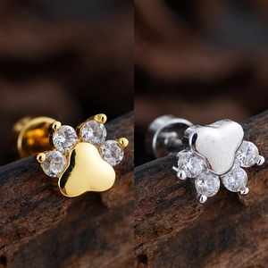 Macro shot of gold and silver paw-shaped ear studs with micro-set cubic zirconia details