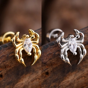 Detail view of spider-shaped cartilage studs with marquise-cut zircon in gold and silver