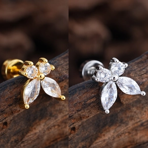 Close-up of flower-shaped stud earrings in gold and silver plating with zircon stones