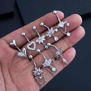Vista detallada de piercings para ombligo de corazón y mariposa con circonitas brillantes