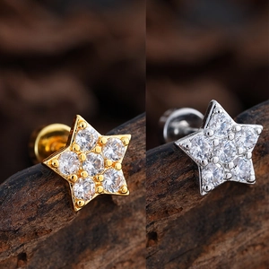 Macro detail of star-shaped stud earrings with pavé cubic zirconia in gold and silver