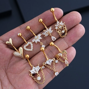 Vista de piercings para el ombligo dorados con circonitas brillantes en forma de corazón