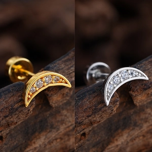 Macro detail of crescent moon earrings with micro-inlaid cubic zirconia in gold and silver