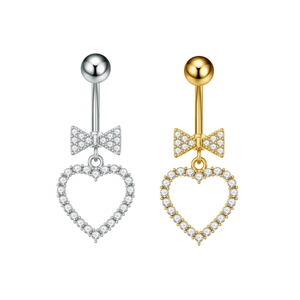 Detalle de piercings de ombligo en plata y oro con lazo brillante y colgante de corazón hueco