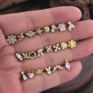 Detailed set of micro-inlaid zircon stud earrings in various gold shapes on a hand palm