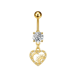 Detalle del piercing de ombligo corazón dorado con grabado de sol luna y circonitas pavé