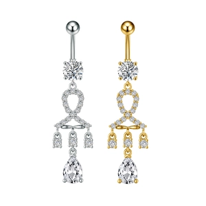 Dettaglio di piercing all'ombelico in argento e oro con nappe di zirconi e pietre a goccia