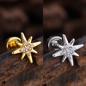 Detailed macro view of gold and silver octagonal star cartilage studs with clear cubic zirconia