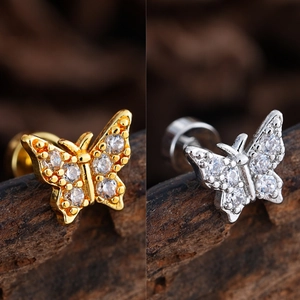 Detalle de piercings de mariposa en oro y plata con circonitas cúbicas brillantes