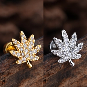 Vista macro detallada de pendientes de siete hojas en oro y plata con circonitas