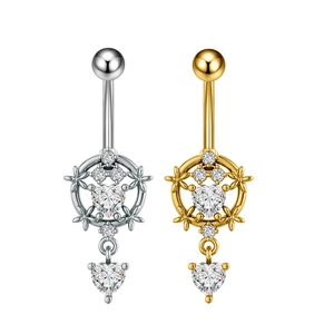 Dettaglio di piercing all'ombelico cuore argento e oro con zirconi e motivi floreali tondi