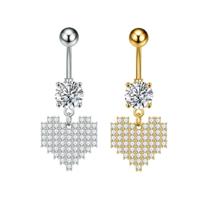 Detalle macro de piercings de ombligo de corazón píxel en plata y oro con circonitas