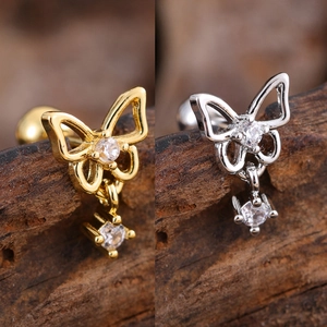 Detailed macro view of butterfly stud earrings in gold and silver with cubic zirconia