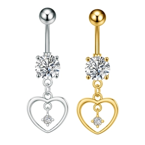 Detalle macro de piercings de ombligo en forma de corazón con circonitas en plata y oro