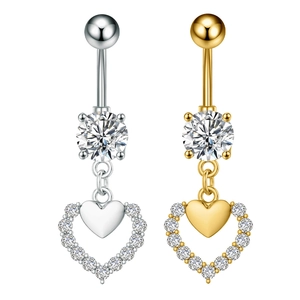 Macro detail of heart shaped belly rings in gold and silver finish with zircon