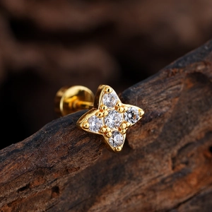 Primer plano de pendiente de estrella chapado en oro con circonitas sobre fondo de madera