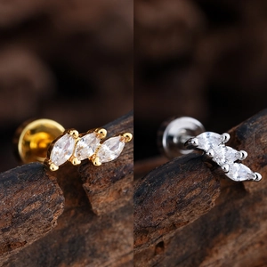 Detalle de pendientes de circonita con corte marquesa en acabados oro y plata