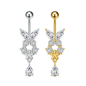Dettaglio dei piercing all'ombelico a farfalla in oro e argento con zirconi lucidi