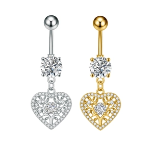 Detalle de piercings de ombligo de corazón en plata y oro con árbol de la vida y circonita