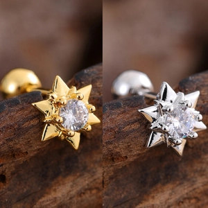 Macro detail of starburst stud earrings with clear zircon in gold and silver finishes