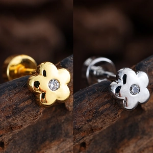 Detalle de pendientes de flor de 5 pétalos en oro y plata con circonitas brillantes