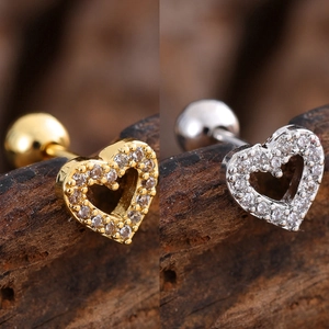 Macro shot of gold and silver heart cartilage studs with pavé cubic zirconia