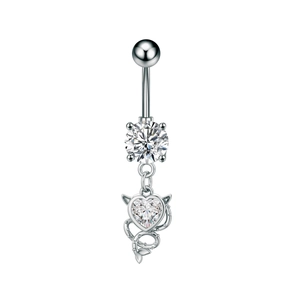 Close-up of heart-shaped zircon devil pendant on a silver stainless steel belly ring