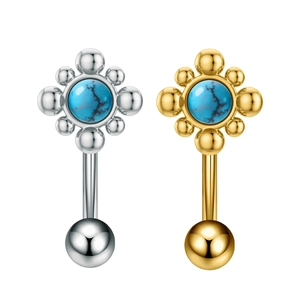 Dettaglio macro di piercing per ombelico in argento e oro con fiori in turchese blu