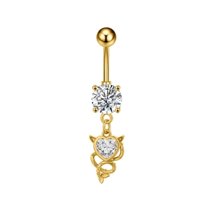 Macro detail of golden heart devil navel ring with sparkling zircon stone and small horns