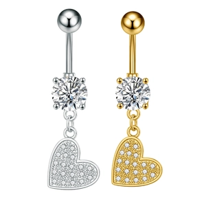 Detalle macro de piercings de ombligo de corazón en plata y oro con circonitas cúbicas