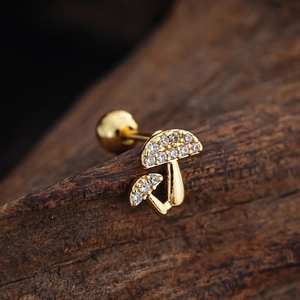 Detailed macro view of golden double mushroom ear studs with zircon on wooden surface