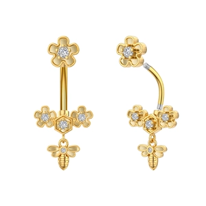 Close-up of gold belly ring with zircon flowers and a detailed bee pendant macro