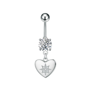 Detalle macro del piercing de ombligo de corazón plateado con grabado y circón