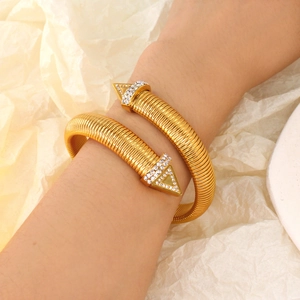 Bracciale a spirale dorato in acciaio al titanio con estremità a triangolo e diamanti
