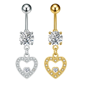 Macro detail of silver and gold belly rings with heart pendants and zircon inlay