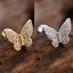 Detailed macro view of gold and silver butterfly earrings with micro-set zircon stones