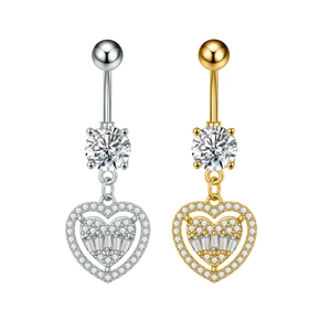 Detalle de piercings de ombligo en forma de corazón en oro y plata con circonitas
