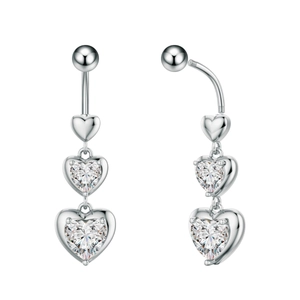 Dettaglio del piercing all'ombelico in acciaio con tre cuori pendenti in zircone