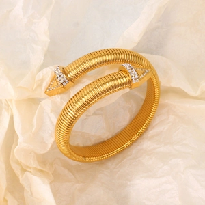 Dettaglio del bracciale elastico in titanio dorato con terminali a freccia in zircone