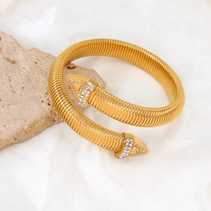 Dettaglio del bracciale a molla placcato oro con punte a freccia tempestate di cristalli fini