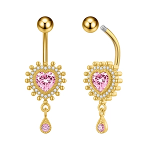 Detalle de un piercing de ombligo dorado con circón de corazón rosa y colgante de gota