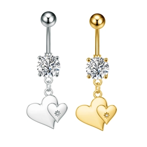Detalle de piercings de ombligo en forma de corazón plateados y dorados con circonitas