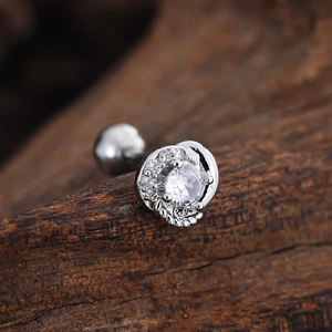 Macro shot of silver spiral stud earring featuring a large round zircon and ball back