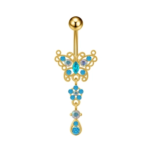 Detalle del piercing de ombligo con mariposa dorada, piedra azul y colgante de flor