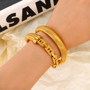 Modern 18K gold-plated serpent coil bracelet with H-link chain on model wrist